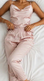 Pijama de cetim rosa pose delicada em estúdio, visual feminino.