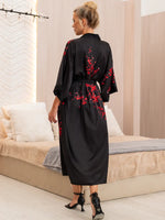 close da estampa floral vermelha sobre fundo preto acetinado
