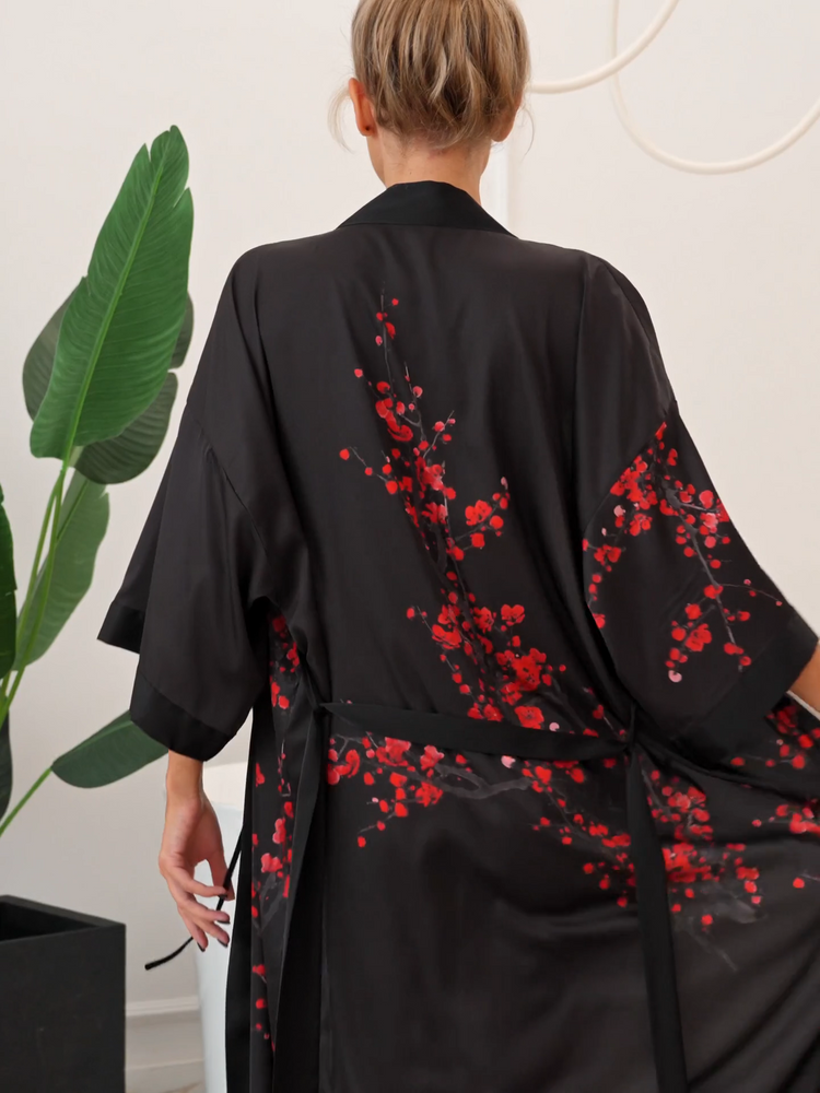 em pé apoiado robe kimono longo preto com laço central ajustado, mostrando a a parte de trás, as costas